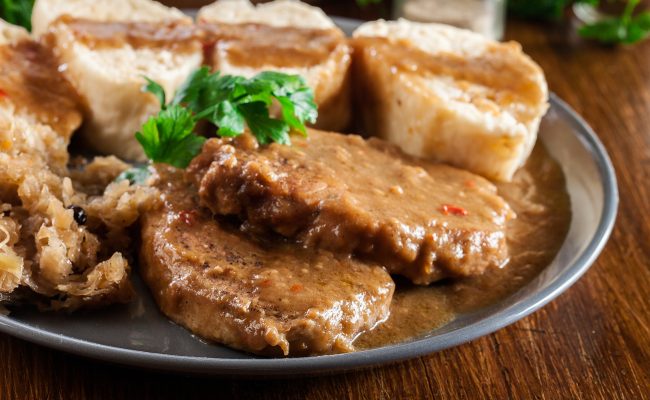 Pork loin in gravy with bread dumplings and sauerkraut. Czech cuisine