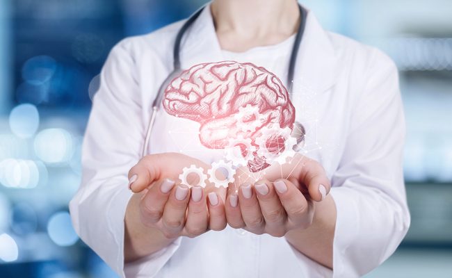 A closeup of young doctor holding the brain image and cogwheel mechanism model in her hands at blurred hospital background.